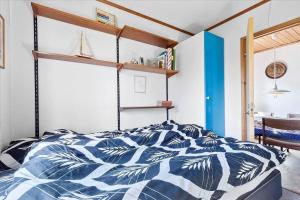 a bedroom with a bed with a blue and white comforter at K20061-Gorlev-Eranthisvej-7 in Gørlev