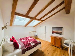 a bedroom with a bed and a desk and a window at Chalet Anna in Unterwössen
