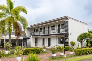 a white house with a palm tree in front of it at Pietros Square in Butuan