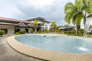 a swimming pool with a fountain in front of a house at Pietros Square in Butuan