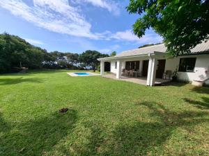 a house with a yard with a pool at RAMBLiNN in Zinkwazi Beach