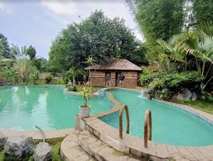 a swimming pool with a gazebo in a garden at Bamaeri Royal Resort in Nongpoh