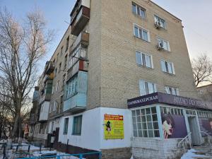 a tall brick building with a sign in front of it at Возле Нарыка in Ekibastuz