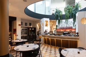 JOIVY Together Florence Urban Resort في فلورنسا: مطعم به طاولات وبار