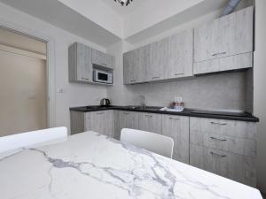 a kitchen with a marble table and white cabinets at La vela latina in Lerici