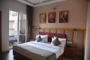 a bedroom with a large bed and a window at Aarush Hotel & Resort in Haldwāni