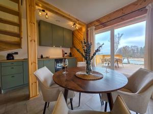 a kitchen and dining room with a table and chairs at Zatoka Warmii in Tomaszkowo