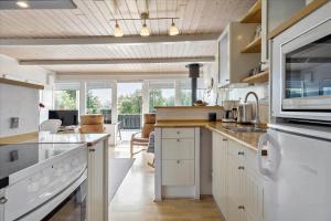 a kitchen with white cabinets and a dining room at SL216-Slagelse-Bildsovej-117 in Slagelse