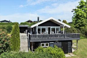 a black house with a porch and a deck at SL216-Slagelse-Bildsovej-117 in Slagelse