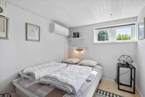 a bed in a white room with a window at SL216-Slagelse-Bildsovej-117 in Slagelse