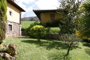 a house with a garden in front of it at El Trebano in Cardes