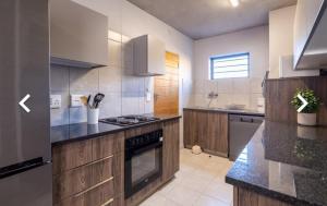 a large kitchen with wooden cabinets and a stove top oven at Private Room in a 2-Bed Apartment Shared in Farmall