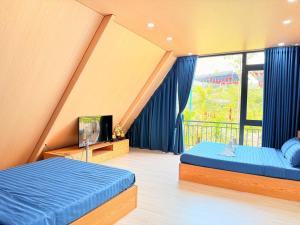 a bedroom with two beds and a large window at Uniton Zen Garden in Ấp Bến Cầu +43 photos