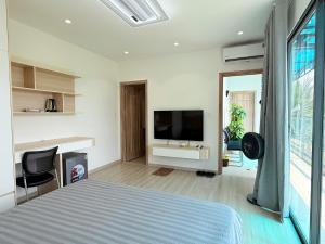 a bedroom with a bed and a flat screen tv at Uniton Zen Garden in Ấp Bến Cầu