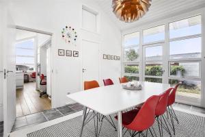 a dining room with a white table and red chairs at SL245-Rude-Fuglevaenget-20 in Rude