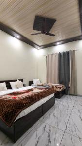 a bedroom with two beds and a ceiling at Amigo's Hotel and Restaurant in Nandaprayāg