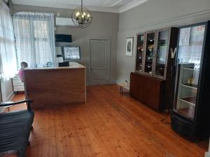 a large room with a counter and a room with wooden floors at Triple9 Hatfield Guesthouse in Pretoria