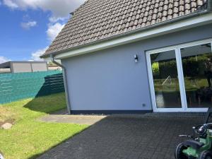 a white house with a large sliding glass door at Little Rostock in Papendorf