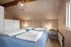 a bedroom with two beds and a wooden wall at K20063-Store-Fuglede-Ostvej-6 in Store Fuglede