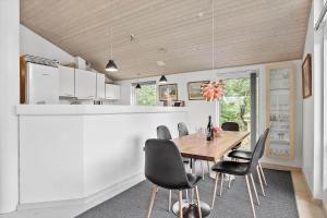 a dining room with a wooden table and black chairs at K19045-Kalundborg-Lobelievej-3 in Kalundborg +17 photos