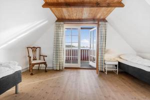 a bedroom with two beds and a chair and a window at SL341-Skaelskor-Glaenovej-140 in Skælskør