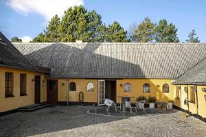 a yellow house with a gray roof and chairs at SL341-Skaelskor-Glaenovej-140 in Skælskør