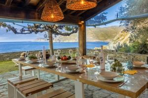 a dining table with a view of the ocean at Villa MARION bord de mer in Pino +9 photos