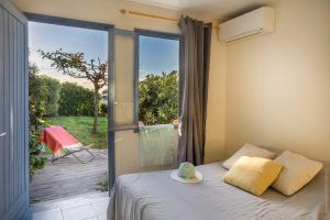 a bedroom with a bed and a sliding glass door at Villa MARION bord de mer in Pino