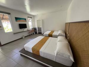 a bedroom with two beds and a television in it at Onda Resort Pacifico in San Isidro