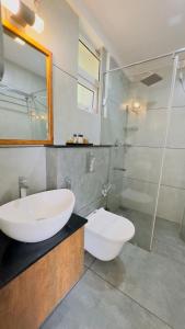 a bathroom with a sink and a toilet and a shower at Amrezy Luxury Resort and Spa, Wayanad in Vythiri
