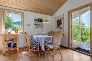 a dining room with a table and chairs and windows at SL347-Korsor-Tvaerager-9 in Korsør