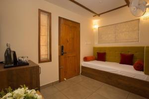 a bedroom with a bed and a wooden door at Amrezy Luxury Resort and Spa, Wayanad in Vythiri