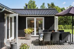 a patio with a table and chairs and an umbrella at K20092-Gorlev-Skovhusvej-27 in Gørlev