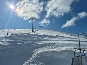 a snow covered slope with people on a ski lift at Apartman Lúčky-Rea in Belá