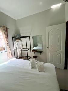 a bedroom with a bed with white sheets and a mirror at Yada House s&s in Nai Yang Beach