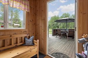 a wooden porch with a bench and an umbrella at KAL097-Gullaskruv-Hetalaga-107 in Gullaskruv