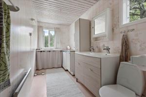 a bathroom with a sink and a toilet and a tub at KAL097-Gullaskruv-Hetalaga-107 in Gullaskruv +15 photos