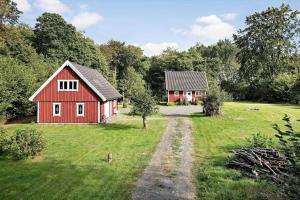 a red barn and a house in a field at SKA580-Perstorp-Oerahult-708 in Perstorp
