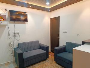 a waiting room with two chairs and a tv at Hotel Assi Retreat in Varanasi