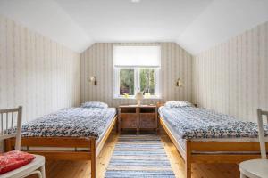 two beds in a room with a window at KAL159-Gullaskruv-Hetalaga-111 in Gullaskruv