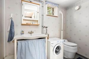 a bathroom with a washing machine and a sink at KAL159-Gullaskruv-Hetalaga-111 in Gullaskruv +21 photos