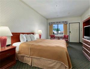 a hotel room with a bed and a television at Travelodge by Wyndham Lynwood in Lynwood