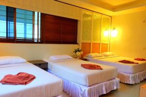 three beds in a room with yellow walls and windows at PSHill in Ao Nang Beach