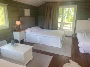 a bedroom with two beds and a table and a window at STO703-Graeddoe-Maroe-77 in Gräddö