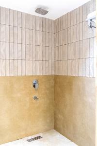 a shower in a bathroom with a tiled wall at Hotel Panipat Prime in Pānīpat +16 photos
