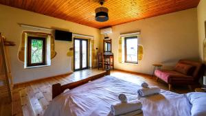 a bedroom with a bed and a couch and windows at Villa Andrianna in Frés