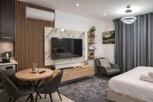 a room with a bed and a television and a table and chairs at LoxwoodStudio by UniqueView in Accra +18 photos