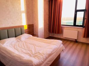a bed in a room with a large window at Onon-Ulz restaurant and hotel in Uldz