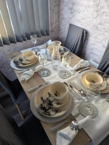 a table with plates and wine glasses on it at Arnside abode in Morecambe +21 photos