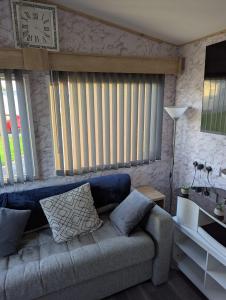 a living room with a couch and a clock on the wall at Arnside abode in Morecambe